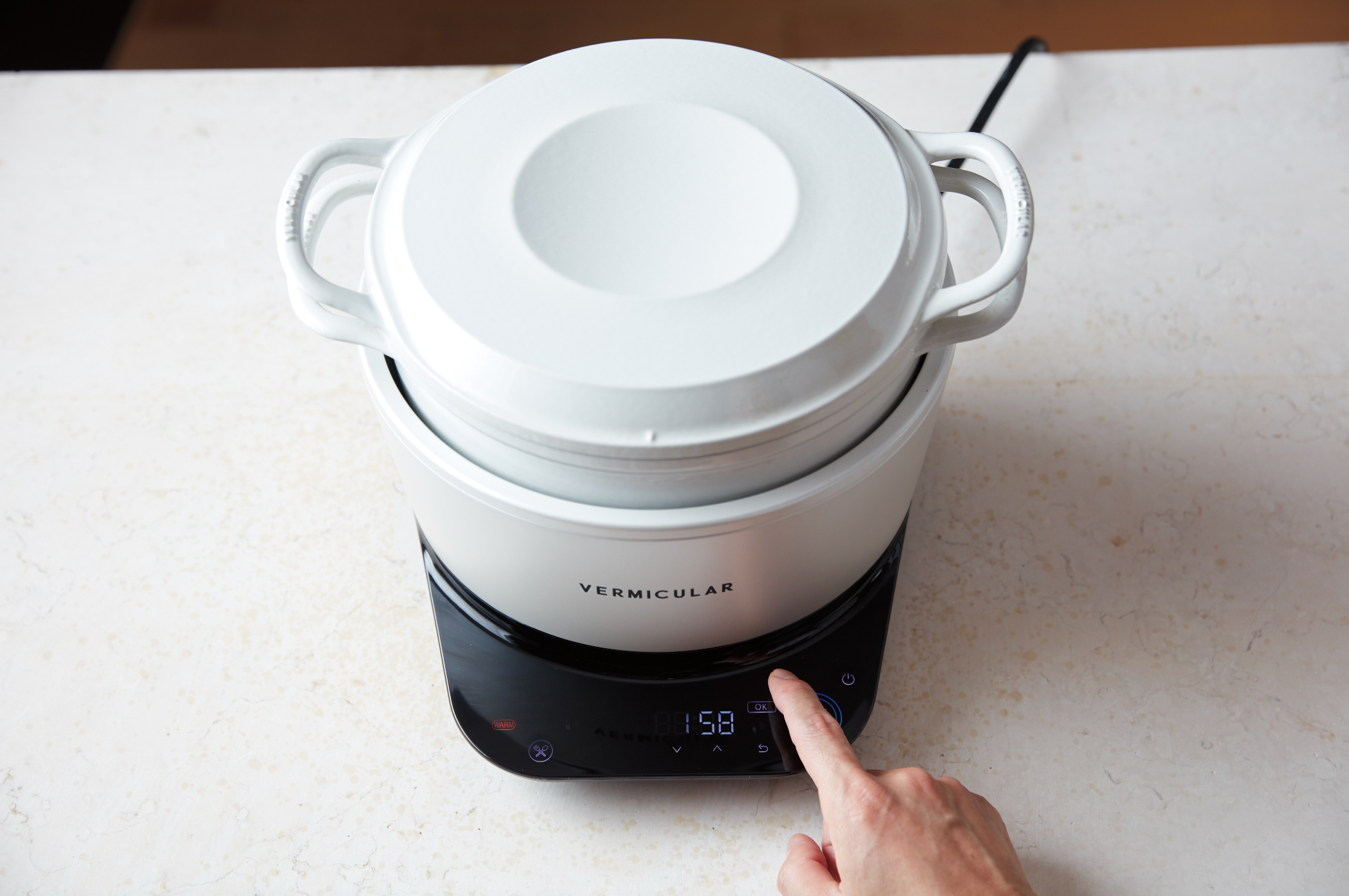 White electric cooker with digital display on a white surface, featuring the brand 'Vermicular'.